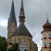 <b>Bad Leonfelden, kostel sv. Bartoloměje</b> (Pfarrkirche Hl. Batholomäus)<br>Území od Kleine Rodl po Haselgraben a od Dunaje po českou hranici patřilo již před rokem 1000 pánům z Wilheringu, kteří se usadili na druhé straně Dunaje.<br> Kolem roku 1100 byl postaven farní kostel v Gramastettenu a jeho pastorační oblast se rozšířila na území dnešního Bad Leonfeldenu. <br>
První zmínka o kostele v Bad Leonfeldenu pochází z roku 1145. <br>
Během husitských válek v první polovině 15. století byl kostel, pravděpodobně dřevěný, vypálen.<br>Nápis na severním portálu s datem 1481 udává, že nová pozdně gotická kamenná stavba byla postavena za opata Tomáše Dienstla ve druhé polovině 15. století. Kostelní věž byla součástí opevnění trhu a až do roku 1781 nesla kulatou věž, která spočívala na římsách. V roce 1781 byla věž zvýšena a barokizována.<br>Interiér byl renovován v roce 1938 a celý kostel v roce 1969. V roce 1980 dostal kostel nové varhany a v roce 1997 novou břidlicovou střechu věže.<hr>28. 8. 2021<br><i>750 m n. m.</i>